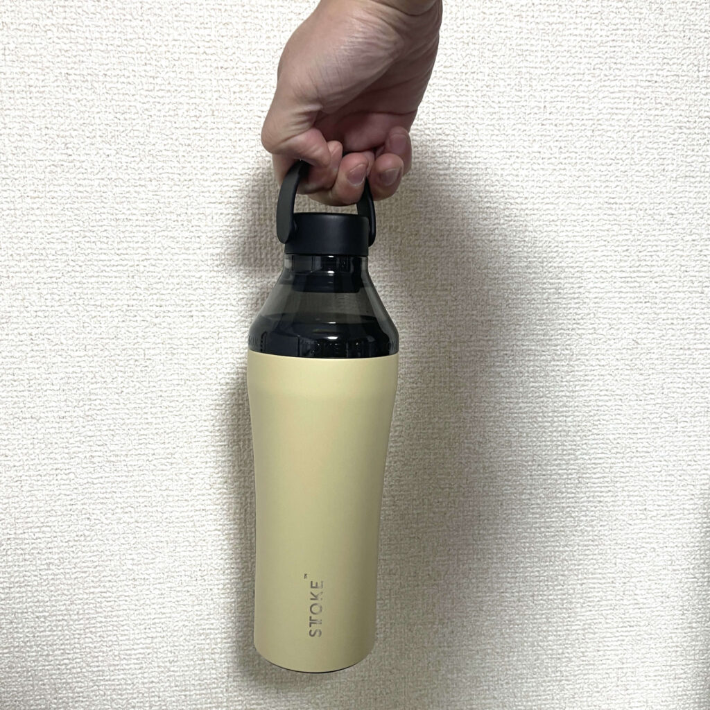 STTOKE（ストーク）タンブラーに専用ボトルキャップを装着し、指に引っ掛けて持ち運んでいる様子