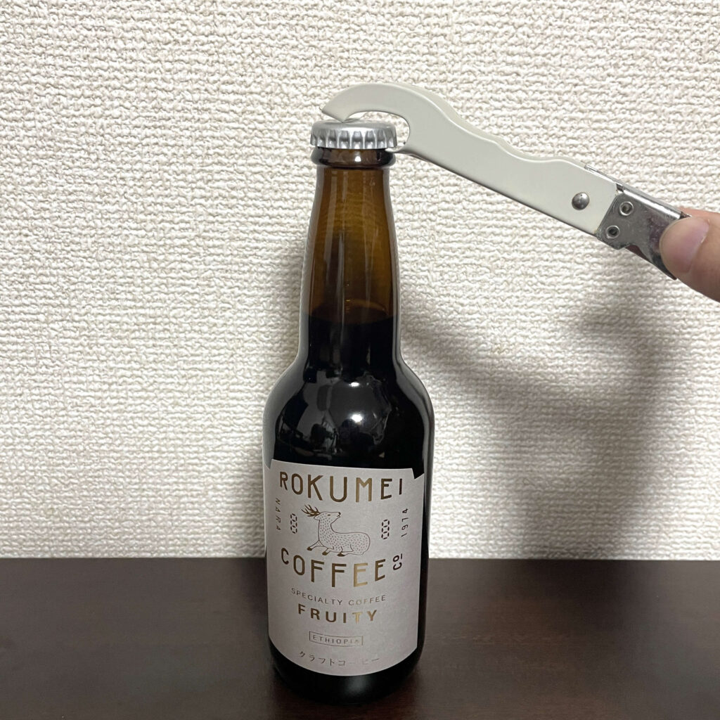 クラフトコーヒーを栓抜きで開ける様子